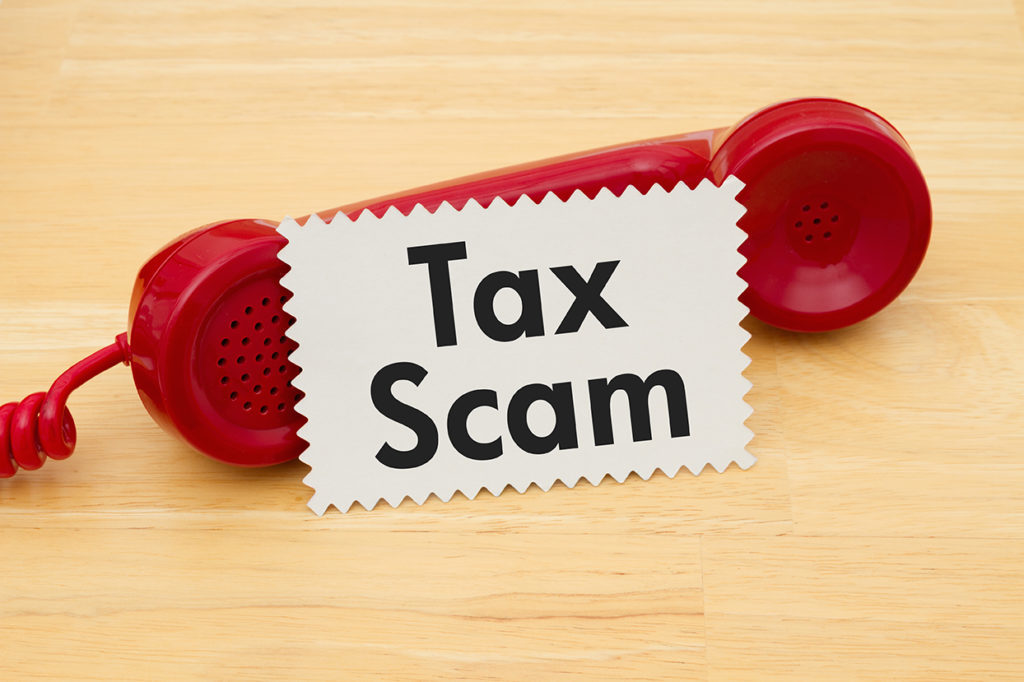 tax scam sign by a phone, irs impersonators