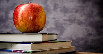 apple sitting on a bile of textbooks